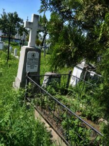 Mormântul părintelui Anton Trifaș, marcat cu o cruce de piatră într-un cimitir.